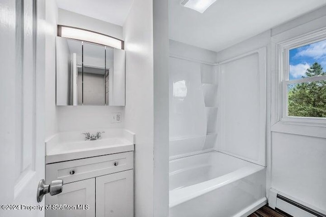 bathroom with shower / bathing tub combination, vanity, and baseboard heating