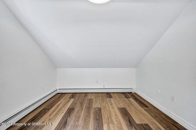 additional living space with hardwood / wood-style flooring, lofted ceiling, and a baseboard radiator