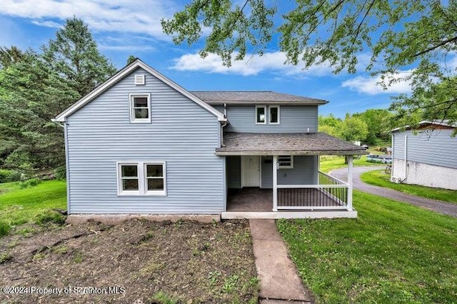 rear view of property with a lawn and a porch