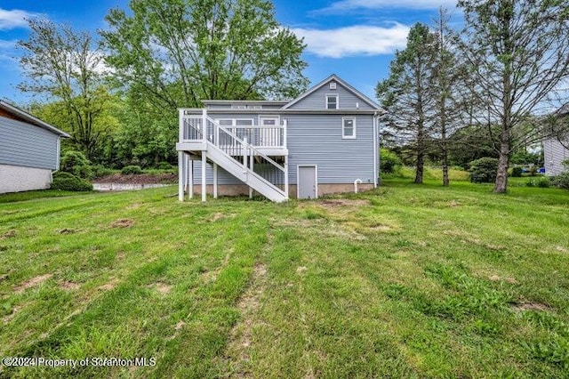 back of house with a deck and a yard