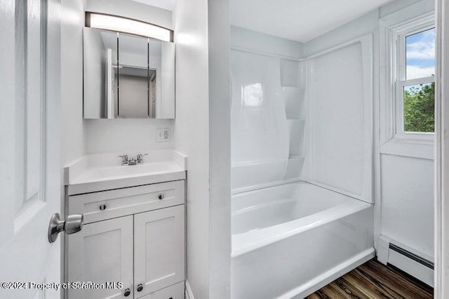 bathroom featuring baseboard heating, vanity, and shower / bath combination