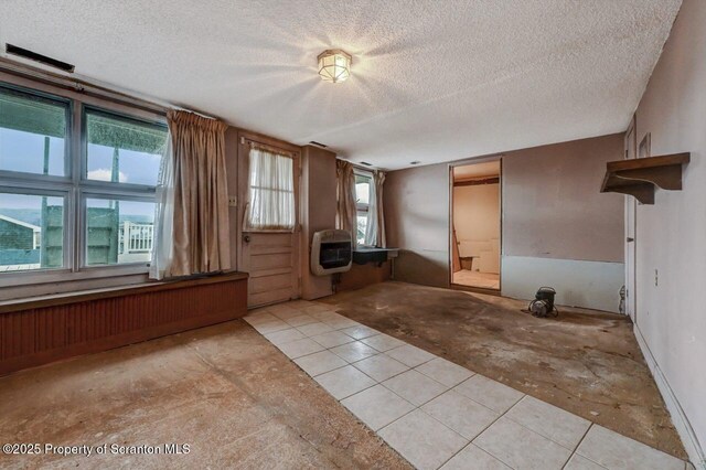 interior space with heating unit and a textured ceiling