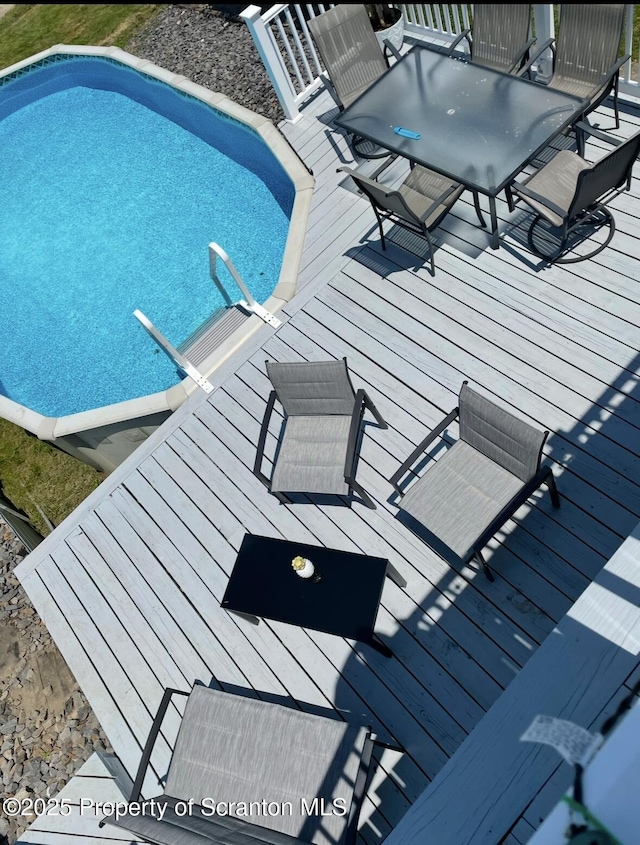 view of pool with outdoor dining area and a wooden deck