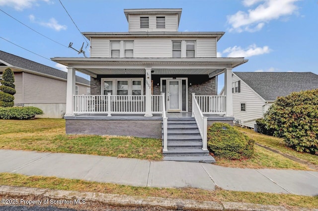 american foursquare style home featuring a front yard and a porch