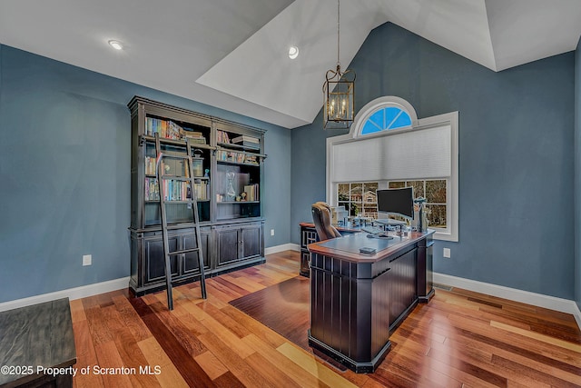 office featuring vaulted ceiling, wood finished floors, and baseboards