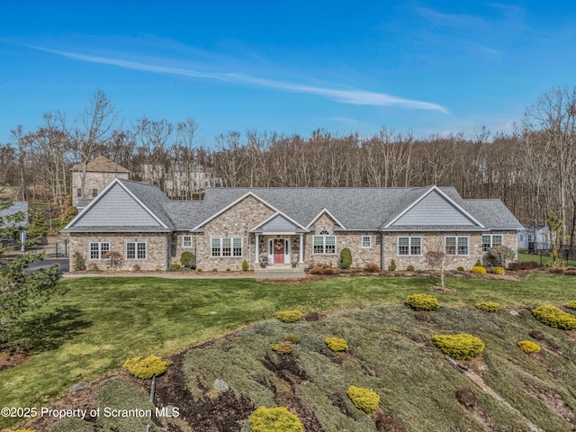 ranch-style home featuring roof with shingles, stone siding, and a front yard