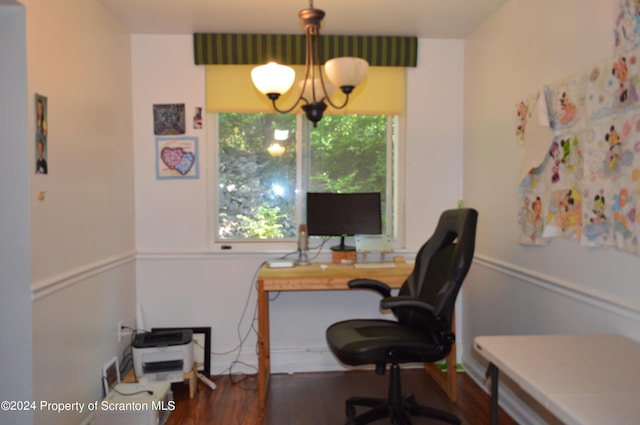 home office with dark wood-type flooring and an inviting chandelier