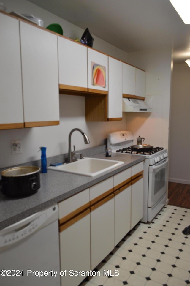 kitchen with white appliances, ventilation hood, white cabinetry, and sink