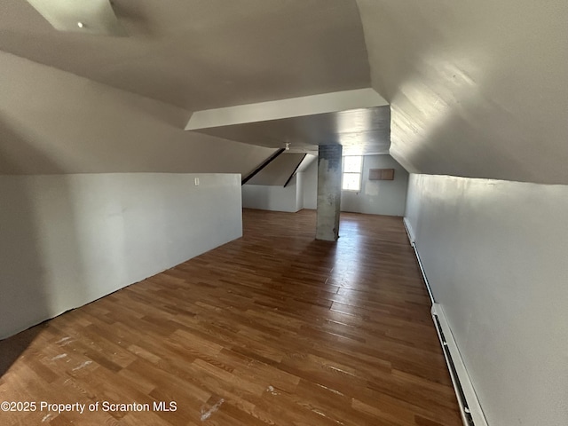 additional living space with a baseboard heating unit, dark hardwood / wood-style flooring, and lofted ceiling