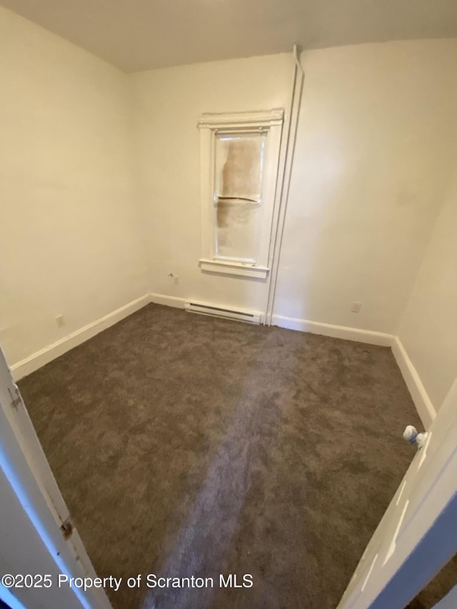 carpeted empty room featuring a baseboard radiator