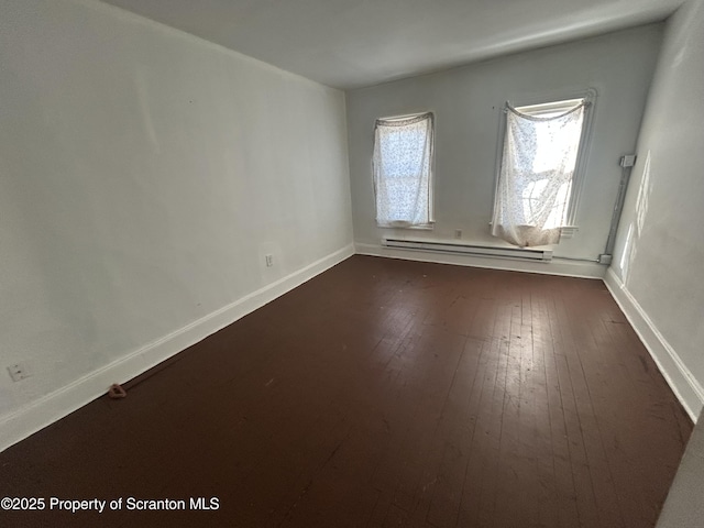 unfurnished room with wood-type flooring and a baseboard radiator