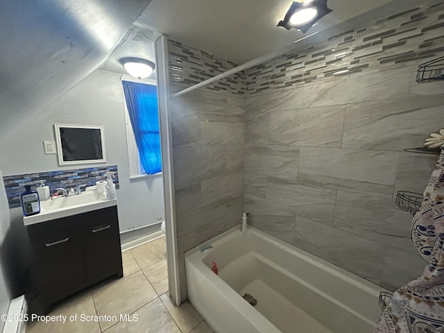 bathroom with tile patterned flooring, vanity, tiled shower / bath, and tasteful backsplash