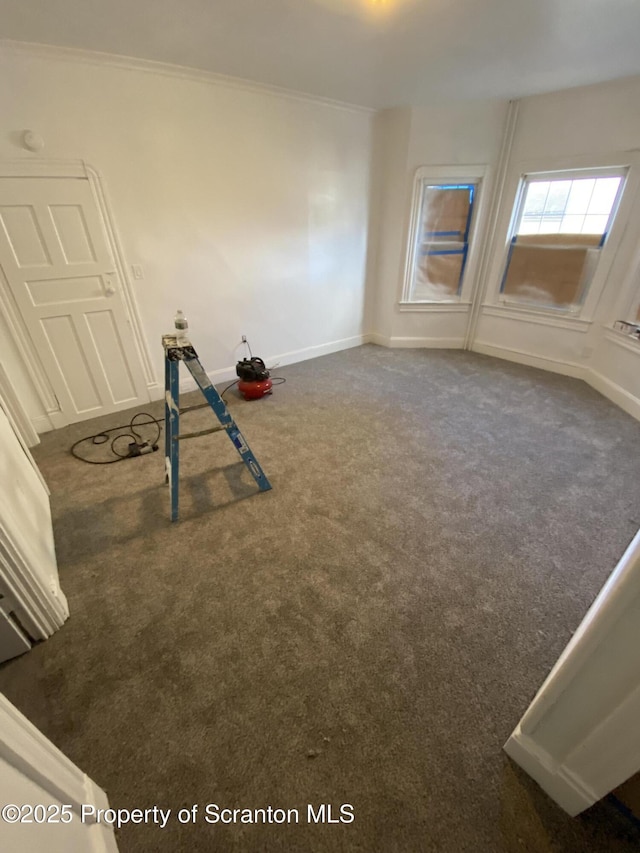 workout room with ornamental molding and dark colored carpet