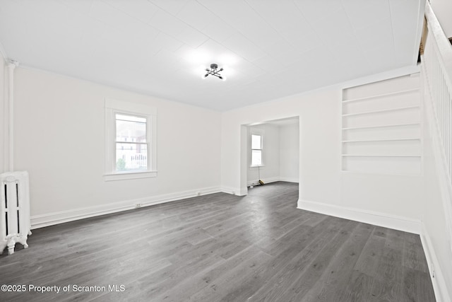 1303 Main St, Pittston, PA 18640 - unfurnished living room featuring radiator, dark wood-style floors, and built in shelves