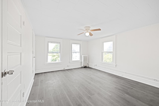 1303 Main St, Pittston, PA 18640 - unfurnished room featuring radiator heating unit, a ceiling fan, and wood finished floors