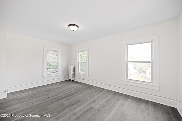 1303 Main St, Pittston, PA 18640 - empty room with radiator heating unit and wood finished floors