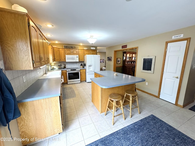 kitchen with white appliances, backsplash, a center island, a kitchen breakfast bar, and light tile patterned floors