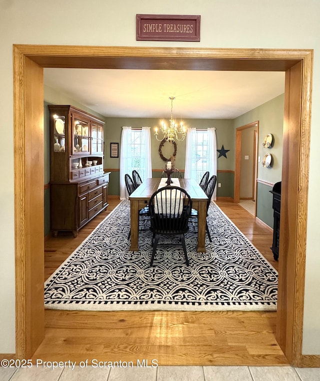 dining room with wood finished floors, a chandelier, and baseboards