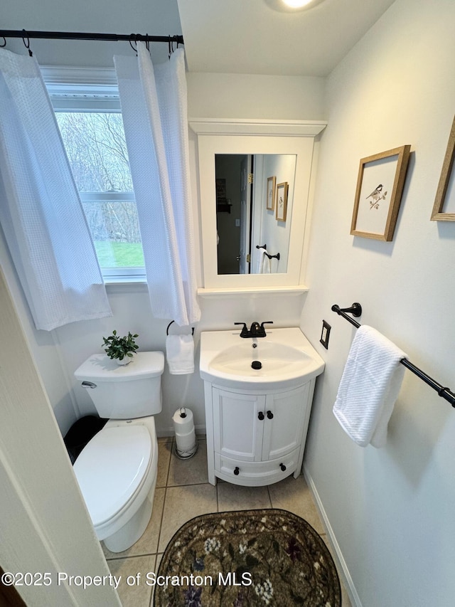 bathroom with tile patterned floors, toilet, vanity, and baseboards