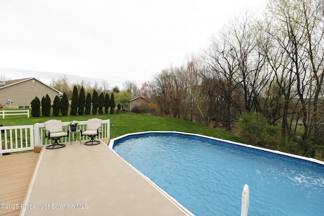 swimming pool featuring a deck and a yard