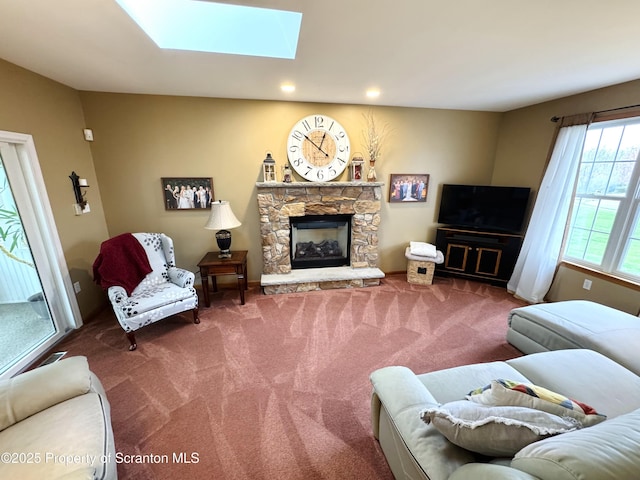 living area featuring carpet floors, a skylight, a fireplace, and recessed lighting