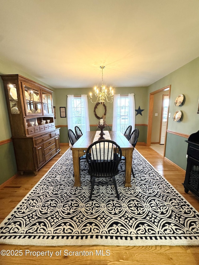 dining room featuring plenty of natural light, light wood-style floors, and a chandelier