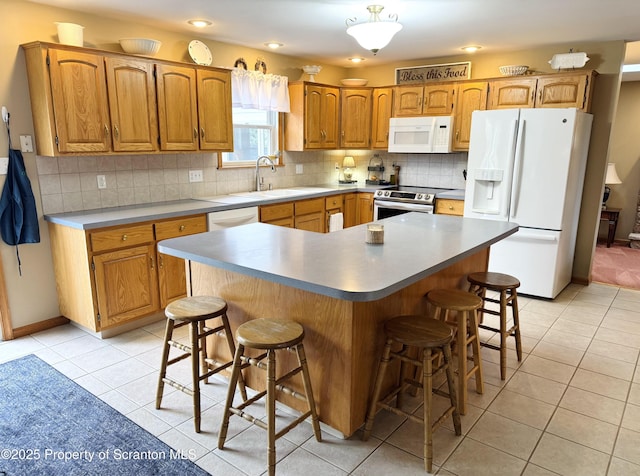 kitchen with white appliances, light tile patterned flooring, a breakfast bar, backsplash, and recessed lighting