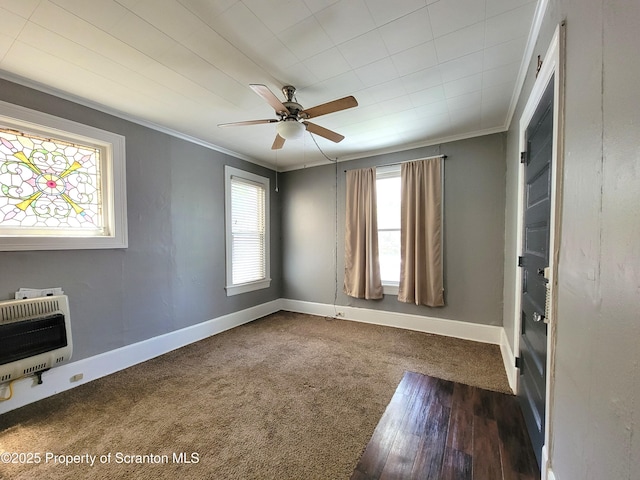 carpeted spare room with crown molding, heating unit, and ceiling fan