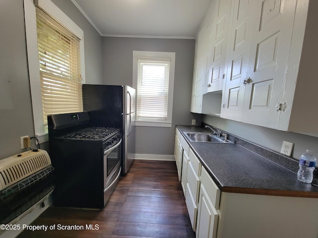 kitchen featuring heating unit, sink, white cabinets, crown molding, and gas range