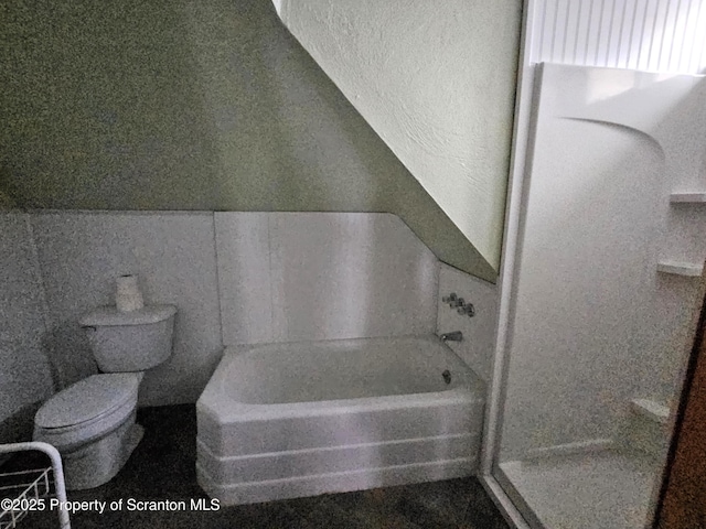 bathroom featuring toilet and a tub to relax in