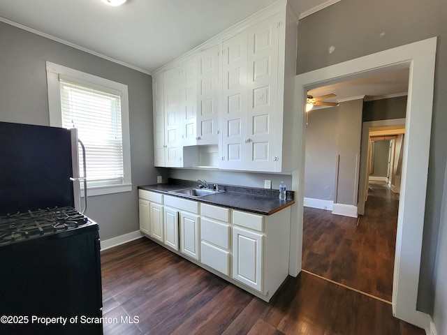 kitchen featuring dark wood-type flooring, sink, crown molding, stainless steel fridge, and white cabinets