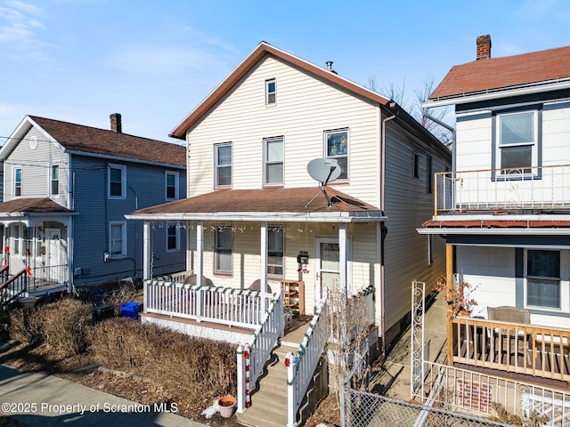 view of front facade featuring covered porch and fence