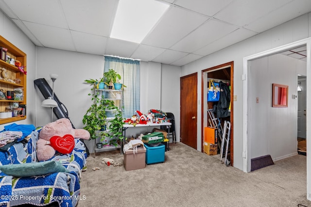 interior space with carpet floors and a drop ceiling