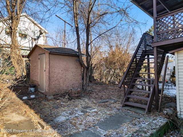 view of yard with stairs, a storage unit, and an outbuilding