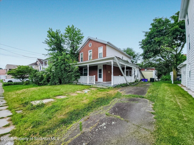 608 E Market St, Scranton, PA 18509 - view of front of home with covered porch, a front yard, driveway, and brick siding