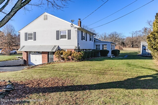 view of home's exterior with a garage and a lawn