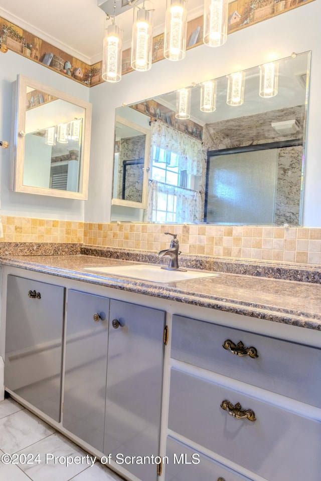 bathroom featuring tile patterned flooring, vanity, ornamental molding, and backsplash