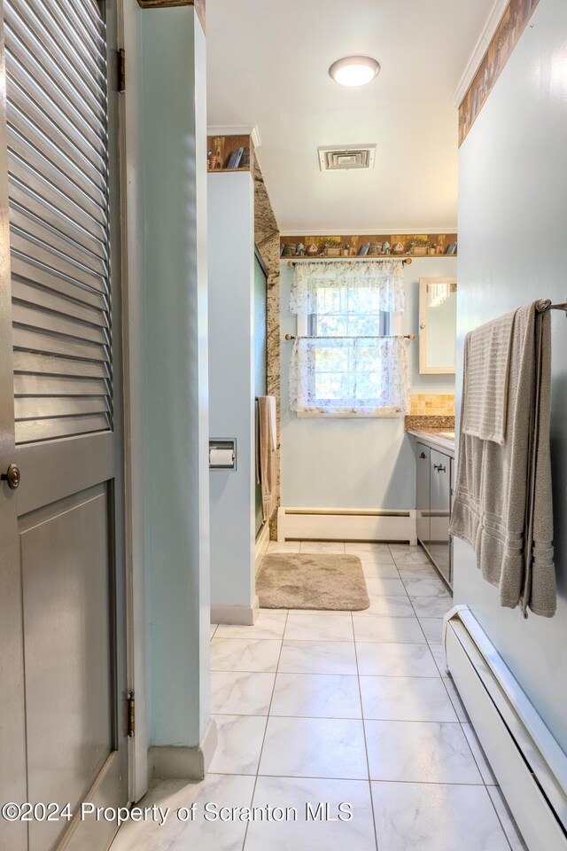 bathroom featuring baseboard heating, tile patterned flooring, vanity, and ornamental molding