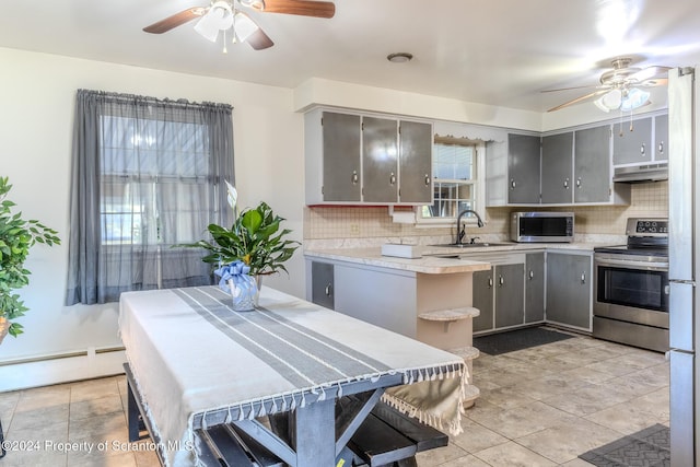 kitchen with baseboard heating, gray cabinetry, sink, and stainless steel appliances