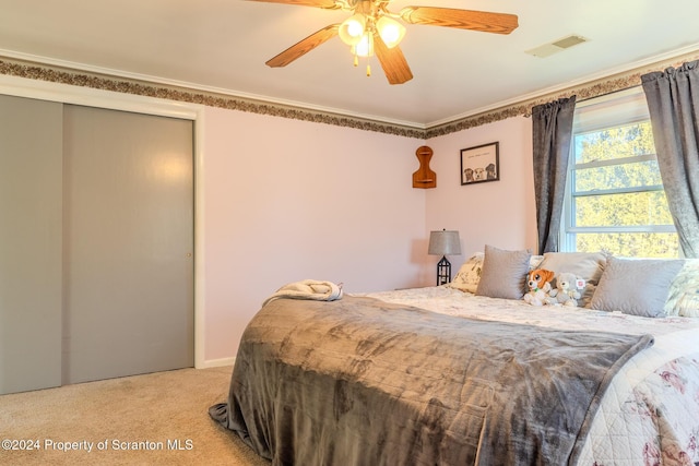 carpeted bedroom with ceiling fan and crown molding