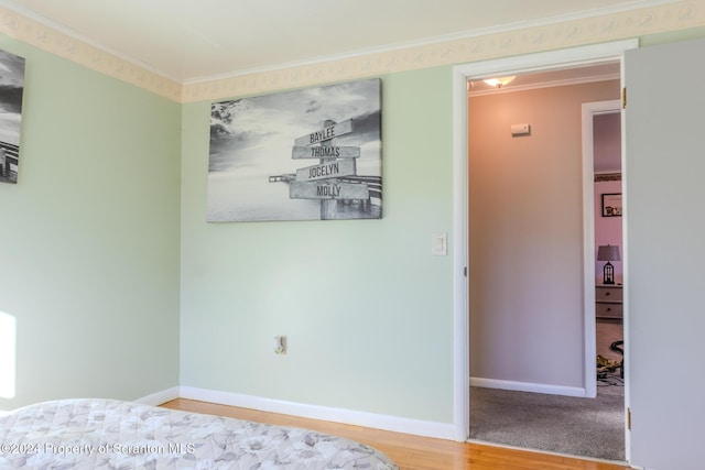 unfurnished bedroom featuring hardwood / wood-style floors and crown molding