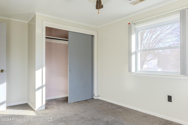 unfurnished bedroom with light carpet, a closet, and crown molding