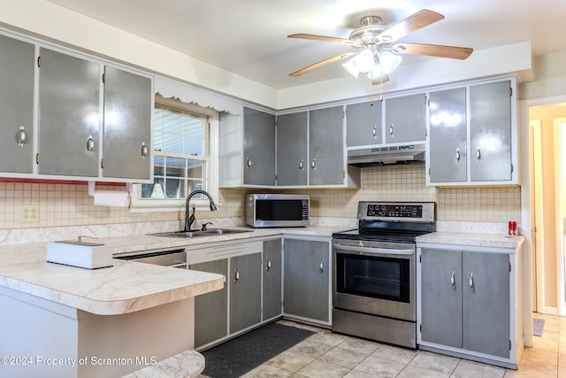 kitchen with kitchen peninsula, appliances with stainless steel finishes, gray cabinetry, and sink