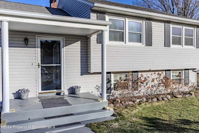 view of exterior entry featuring a yard