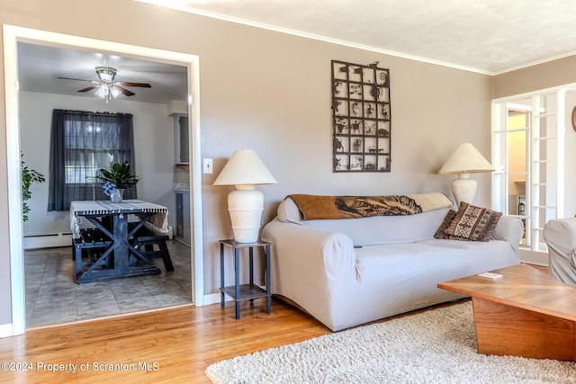 living room with wood-type flooring, a baseboard radiator, ceiling fan, and ornamental molding