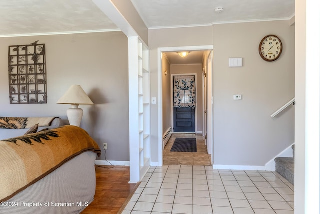 tiled foyer featuring baseboard heating and ornamental molding