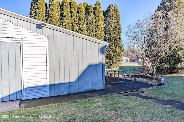 view of home's exterior with a yard and a storage unit