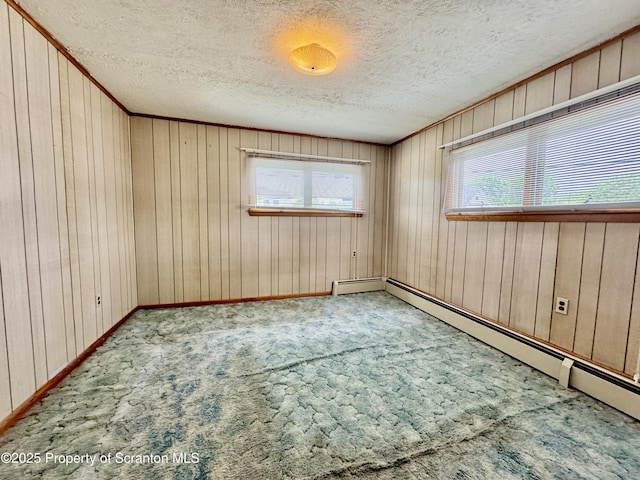 2052 Farr St 2050, Scranton, PA 18504 - carpeted empty room featuring healthy amount of natural light, baseboard heating, a textured ceiling, wooden walls, and baseboards