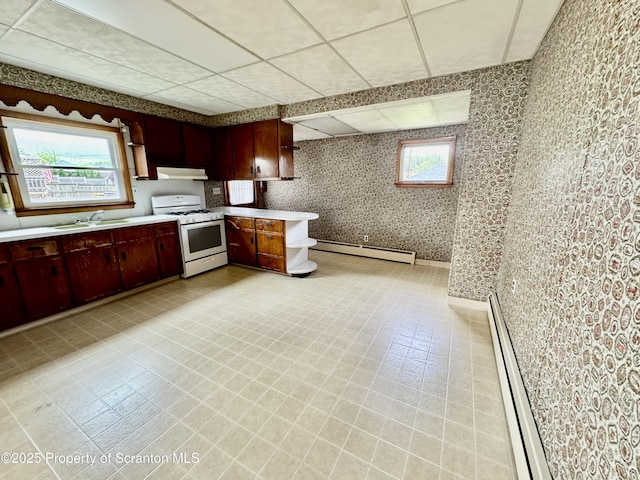 2052 Farr St 2050, Scranton, PA 18504 - kitchen featuring white gas range oven, a baseboard heating unit, a sink, light countertops, and under cabinet range hood