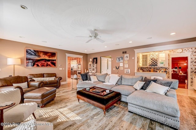 living room featuring ceiling fan and light hardwood / wood-style floors